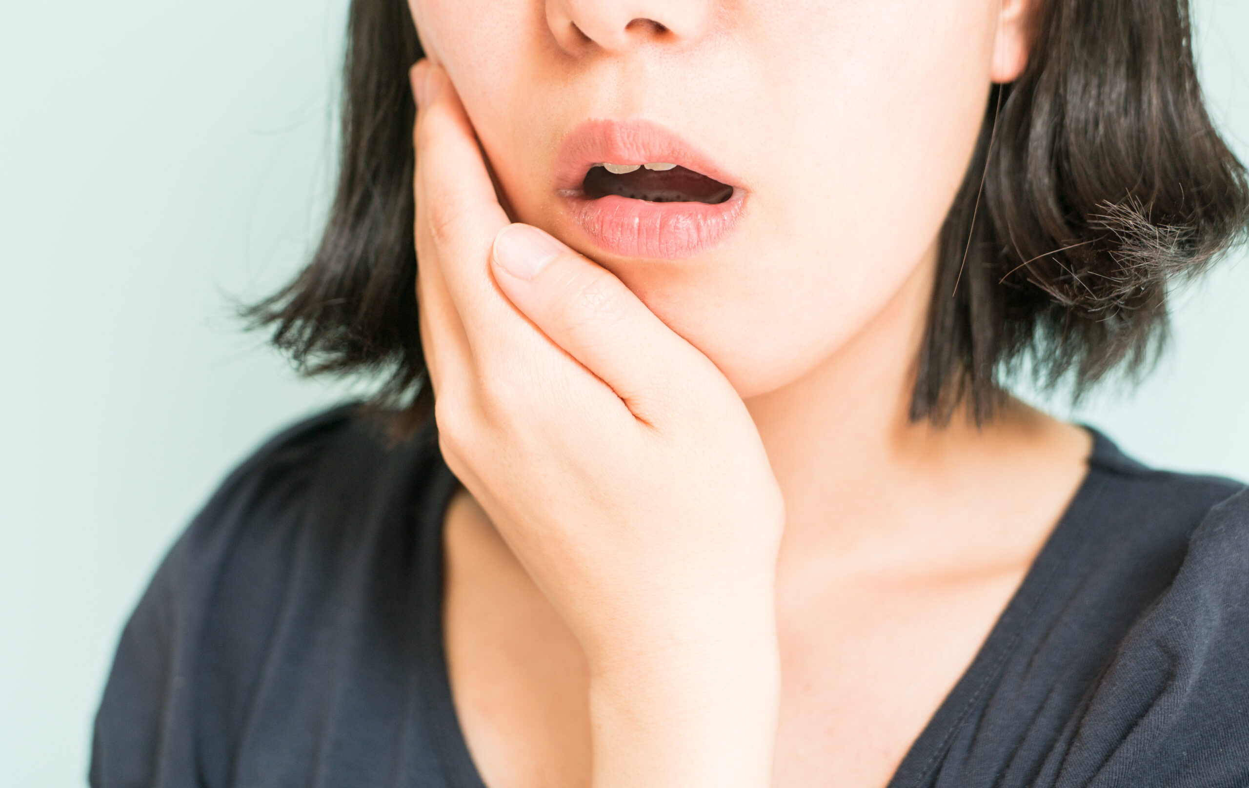 歯の痛みから顎を抑える女性